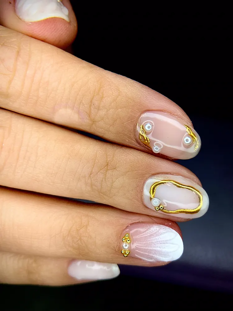 Manicure en tono nude con detalles dorados y perlas